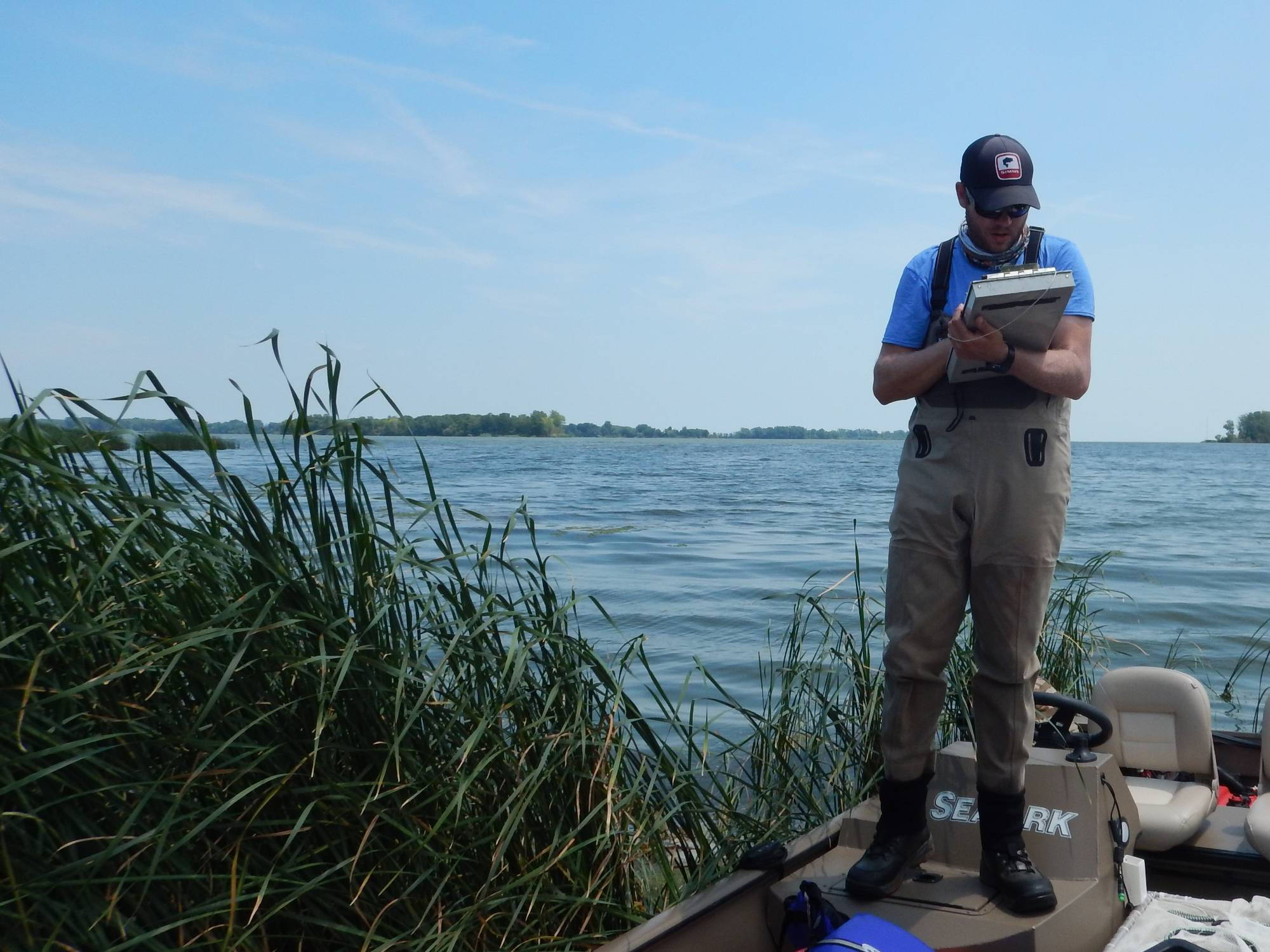 Travis Ellens records data on a clipboard.